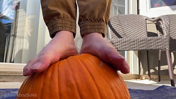 Boy bare feet smashes pumpkin and plays with it