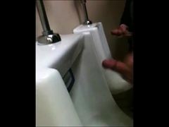 two slim dicks getting wanked at the urinals