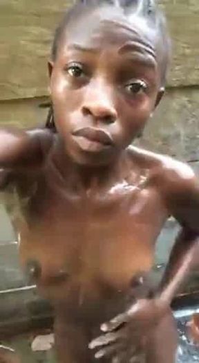 African girl takes a shower outside