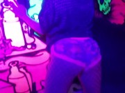 Sexy chick dancing, booty poppin in black light room.