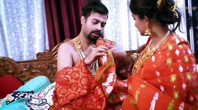 Passionate lovers entwined in a richly decorated bedroom adorned with gold and silk