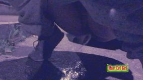 Girl alone at night in a parking lot lowers her pants outdoor to piss