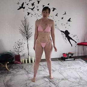 Aurora Willows stretching in a pink bikini