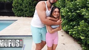 Petite girl and huge man playing naughty by the pool