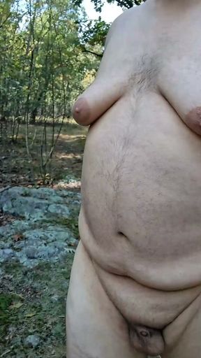 Chubby guy strips, leaves clothes behind and cums in the woods