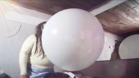 Blowing a green giant Balloon until it pops