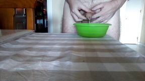 John is peeing into a green bowl on the table