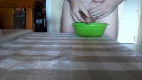 John is peeing into a green bowl on the table