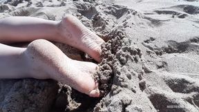Mistress legs barefoot on the summer sea beach
