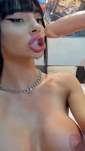 Busty camgirl sucks huge dildo while spitting on it
