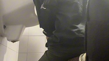 2 boys in sneakers having fun at public toilets' urinal