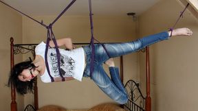 Ballgagged barefoot Ola in white t-shirt and blue jeans, suspended with violet hemp rope sideways, is tickled by camera man (HD MP4)