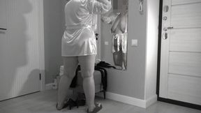 A mature, fat milf with big, saggy tits is changing clothes in front of the mirror.