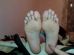 Tickling her feet with fingers while she try to watch movie