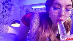 ”University Whore with glasses is sucking a transparent dildo.”