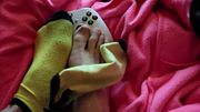 Feet and ankle socks playing with gaming controller