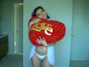 Black haired cutie hugs her big heart pillow on webcam