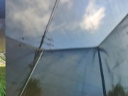 Tall girl in shorts jumping barefooted on a trampoline (slowed down) bottom view