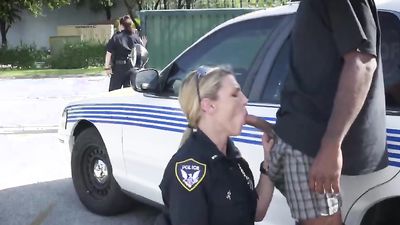 Blonde cop sucking big tits friend and taking a big black dong outdoors on the squad car