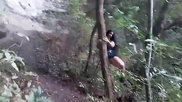 Sluty brunette is giving a blowjob to a random stranger, while they are alone in the forest