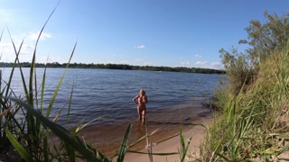 Fishermen swim past a beautiful nudist woman