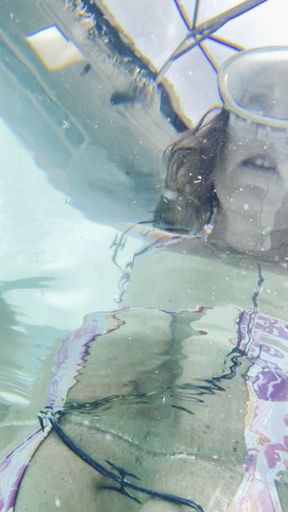 Carissa underwater in a microbikini and wrapped loosely in barbed wire