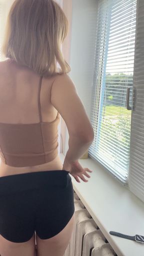 Woman in black bra looking out window
