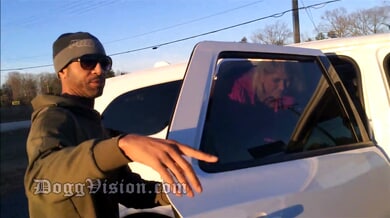 Curvy blonde in pink jacket meets bearded man by white pickup on suburban road