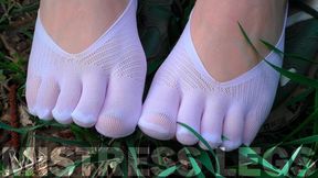 Beautiful Feet in White Socks Jeaning on the Grass Field