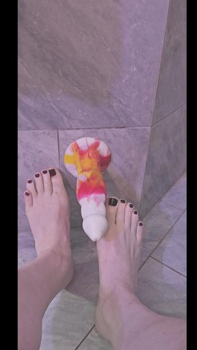 Femboy gives barefoot and bare-legged footjob to dildo