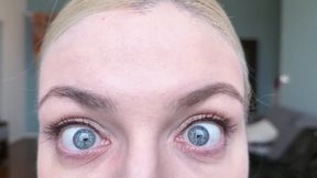 Blonde girl stares at you with her natural sky blue eyes