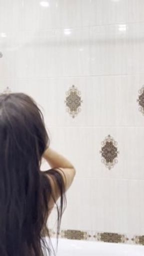 A student washes herself in a bathtub with foam. Light erotica