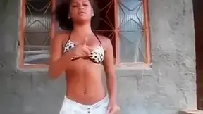 Oriental cutie in swimsuit dancing for viewers in the public