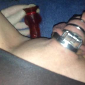 Sissy in chastity playing with red dildo