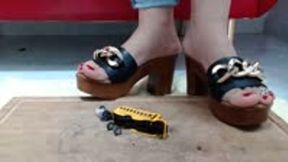 Crushing in wooden Sandals Heel a Schoolbus Metal Toycar