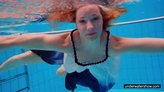Teen girl Avenna is swimming in the pool