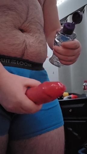 Chubby guy jerking off with condom through underwear hole
