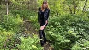 a girl in high-heeled leather boots walks through the mud and falls into a large knee-deep puddle