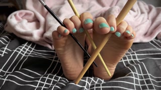 Friend tickles my soles with painting brushes. Close up feet worship