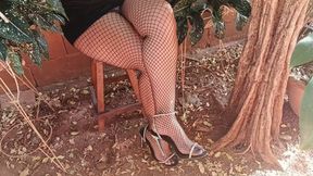 With fishnet stockings and high heels on her feet, woman crosses her legs (3)