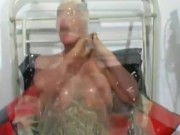 Hot milf with latex condom hood on her head and rubber sheet has fun with breathing games