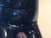 Rubber gimp in chastity shows off