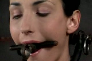 Slim brunette with a gag in her mouth is punished by her master