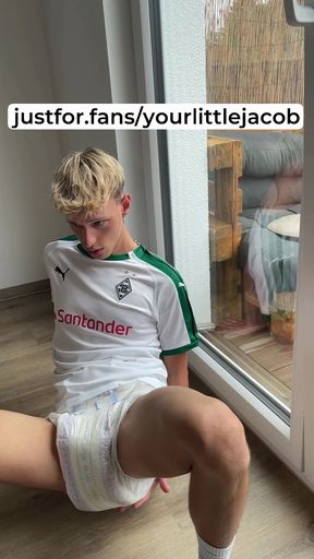 blond soccer boy shows his full diaper under his shorts