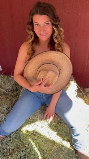 Woman in cowboy hat holding straw hat