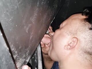 pair sucking dongs at Gloryhole at swing party
