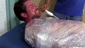 Jock Clint wrapped up to have his feet tickled BDSM style