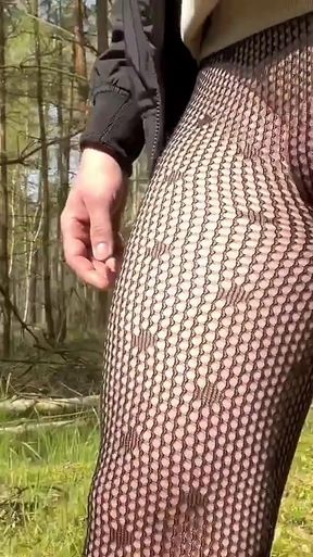 Walking in a park in fishnet tights.