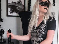 Masked mistress practicing handjob skills on a black toy