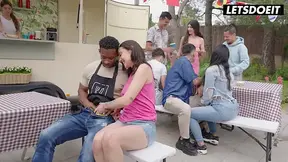 Public cowgirl rides and shows off big tits on a picnic table with crowd